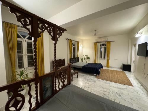 a living room with a bed and a balcony at Super Deluxe Suite in Champa Villa in Gandhinagar