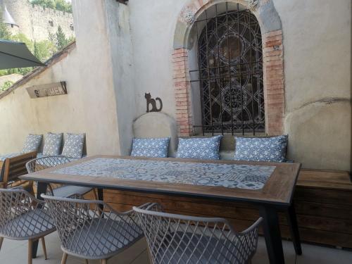 une table et des chaises sur une terrasse avec une fenêtre dans l'établissement Le Belvédère St Gimer, à Carcassonne