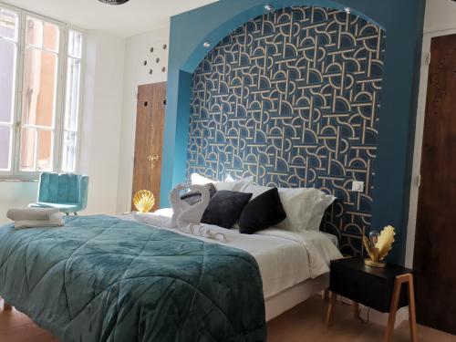 une chambre avec un grand lit avec un mur bleu dans l'établissement Le Belvédère St Gimer, à Carcassonne