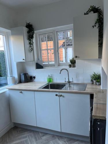 a kitchen with white cabinets and a sink at Victorian Town House in the Heart of Dover in Dover