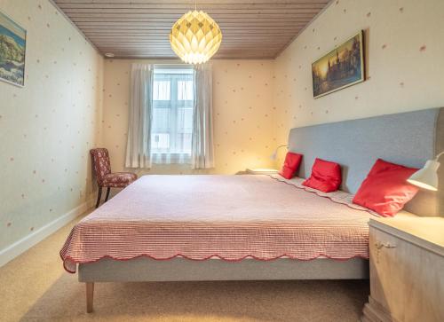 ÅkirkebyにあるCharming, spacious, sea view guest houseのベッドルーム1室(大型ベッド1台、赤い枕付)