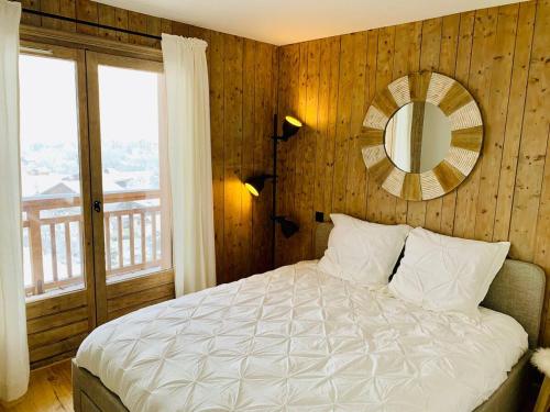 une chambre avec un lit avec un miroir au mur dans l'établissement Magnifique appartement au coeur de Megève, à Megève