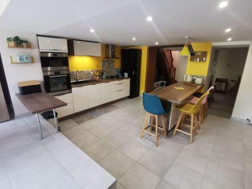 a kitchen with a table and some chairs in it at Vespa Casa in Cherbourg en Cotentin