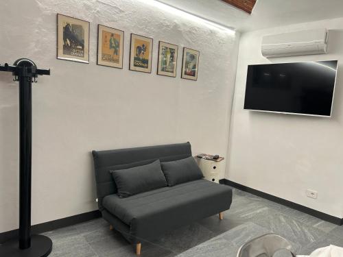 Una sala de estar con un sofá y un televisor de pantalla plana. en Casa del Mercante in centro ad Asti no ztl, en Asti