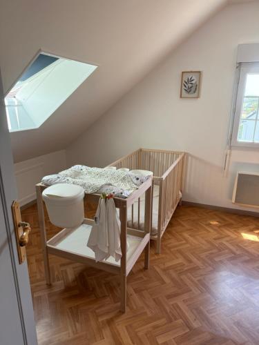 Cette chambre mansardée comprend une table et une lucarne. dans l'établissement Maison La Dune, à Gouville-sur-Mer