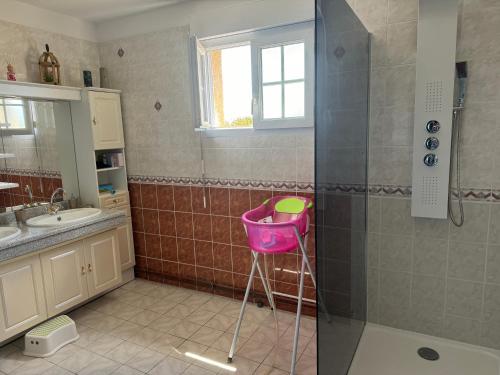 - une salle de bains pourvue d'une douche avec un panier rose dans l'établissement Maison La Dune, à Gouville-sur-Mer