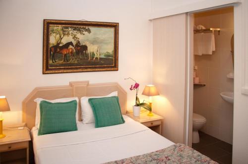 1 dormitorio con cama y una pintura de caballos en Castel De Siam en Houlgate