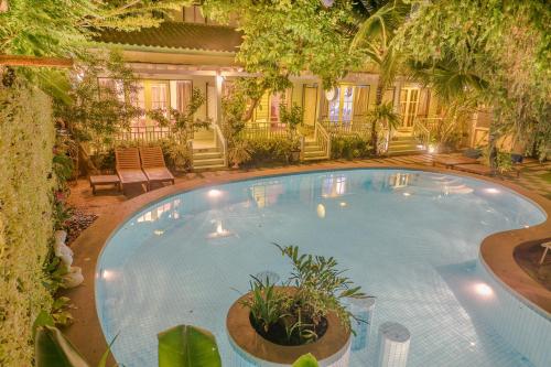 a large swimming pool with plants in a yard at Green Gallery Beach Boutique Hotel in Hua Hin