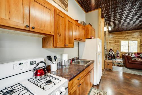 a kitchen with wooden cabinets and a white stove top oven at Pet-Friendly Cabin Retreat Walk to Lake Pepin! in Stockholm