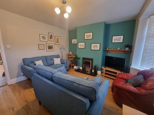 a living room with two blue couches and a fireplace at Central Lancaster City Centre Terraced Gem in Lancaster