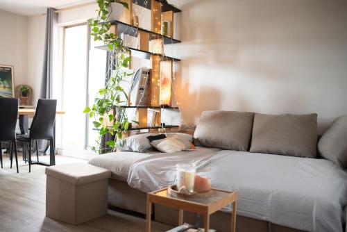 un salon avec un canapé et une table dans l'établissement Les terrasses illuminées - T3 avec parking gratuit, à Toulouse