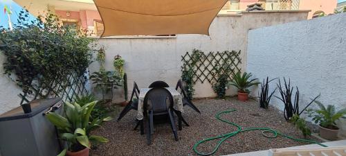 a patio with a table and chairs and plants at Casa Giò in Assemini