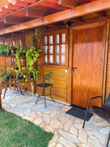 a front door of a house with chairs and a table at Pousada Canastra Sul in Delfinópolis