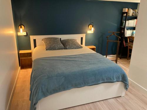 une chambre avec un lit avec un mur bleu dans l'établissement Joli appartement avec jardin-Parc de la Villette, à Le Pré-Saint-Gervais