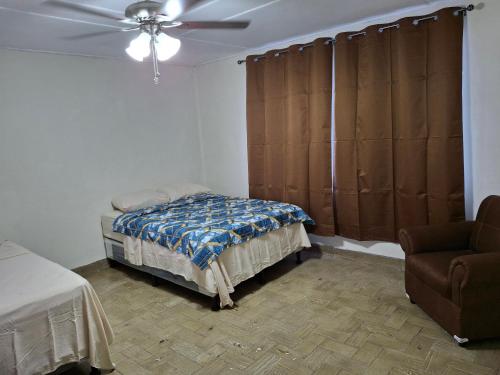 a bedroom with a bed and a ceiling fan at Hostal primaveras habitación 1 in Santa Ana