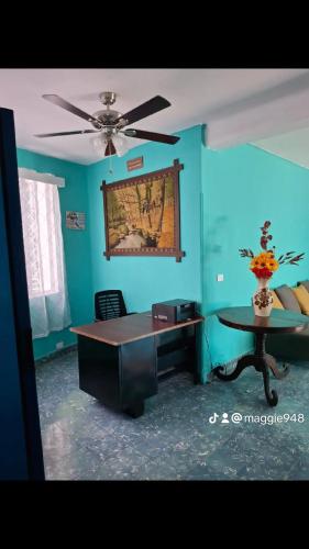 a living room with a table and a ceiling fan at Hostal primaveras habitación 1 in Santa Ana