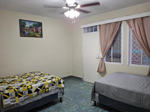 a bedroom with a bed and a ceiling fan at Hostal primaveras habitación 1 in Santa Ana