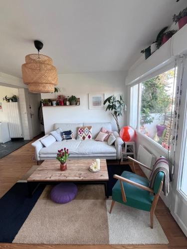 un salon avec un canapé et une table dans l'établissement Appartement lumineux et calme, à Anglet