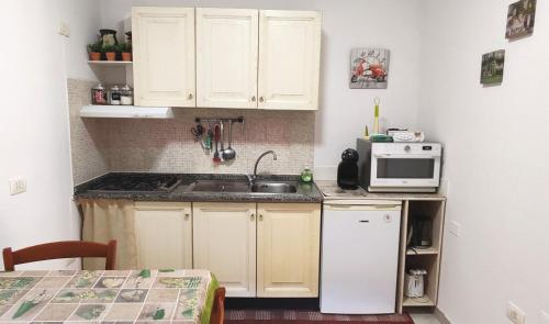 a small kitchen with a sink and a microwave at Casa Giò in Assemini