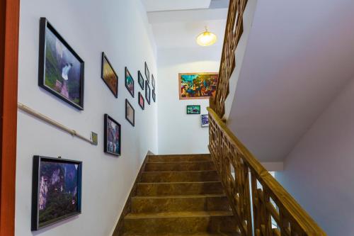 a hallway with stairs with paintings on the wall at Zhangjiajie Jijiehao Inn in Zhangjiajie