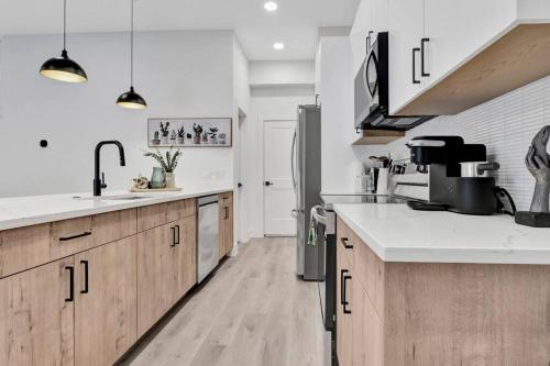 a kitchen with white counter tops and wooden cabinets at Perfect Dallas Oasis l Pet Friendly l Big Backyard in Oldham