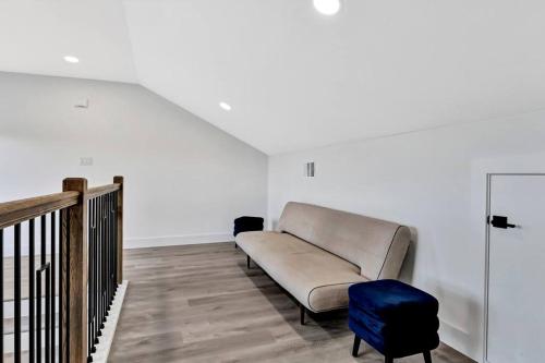 a living room with a couch and a blue ottoman at Perfect Dallas Oasis l Pet Friendly l Big Backyard in Oldham
