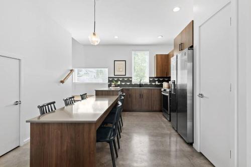 a kitchen with a table and a refrigerator at South Side Modern - Downtown Living - Amazing Location in Chattanooga