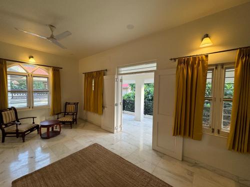 a living room with yellow curtains and a table and chairs at Balcony Suite in Champa Villa in Gandhinagar