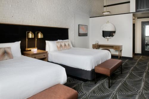 a hotel room with two beds and a table at The Ansonborough in Charleston