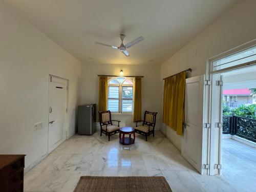 a living room with two chairs and a table at Balcony Suite in Champa Villa in Gandhinagar