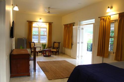 a bedroom with a bed and a living room at Balcony Suite in Champa Villa in Gandhinagar