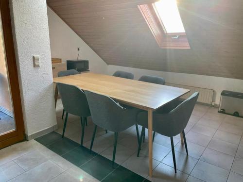 a wooden table and chairs in a room at Appartio - Ferienwohnung "Dorfblick" Dachgeschoss - 6 Personen - Netflix - Waschmaschine in Hofheim in Unterfranken