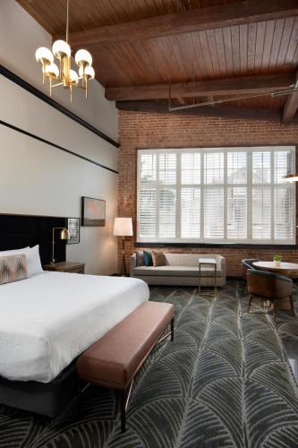 a hotel room with a large bed and a couch at The Ansonborough in Charleston
