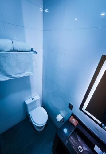 a blue bathroom with a toilet and a tv at HOTEL AZUL AGAVE in Arandas