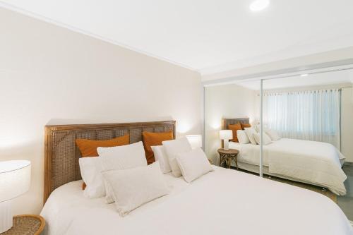 a bedroom with two beds and a mirror at Glenelg Apartment in Murwillumbah