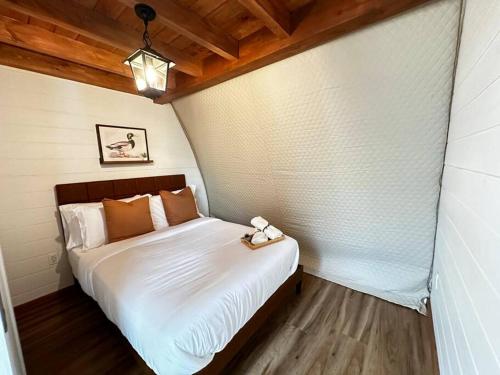 a bedroom with a white bed with a wooden floor at Sunken Escapes Glamping Unit #1 in New Minas