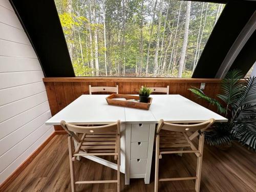 a table and chairs on a screened in porch with a window at Sunken Escapes Glamping Unit #1 in New Minas