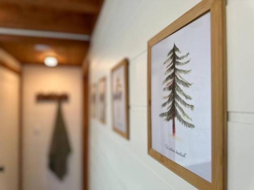 a row of framed pictures of a pine tree on a wall at Sunken Escapes Glamping Unit #1 in New Minas