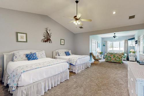 Un dormitorio con dos camas y un ventilador de techo. en Dream in the Keys, en Key Colony Beach
