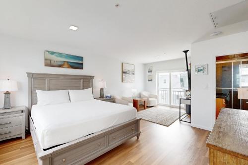a white bedroom with a bed and a living room at Mermaid's Retreat in Marathon