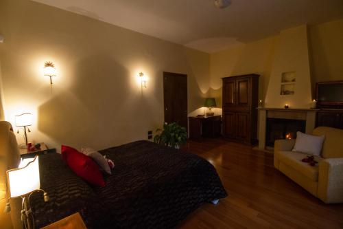 a bedroom with a bed and a couch and a fireplace at Camere al Borgo in Forchia