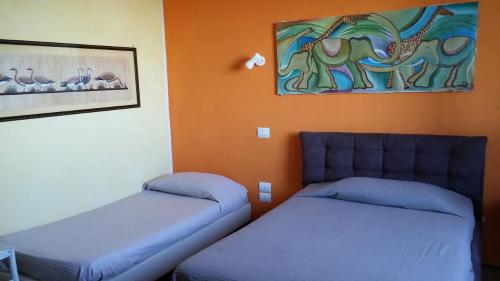 een slaapkamer met 2 bedden en een schilderij aan de muur bij Casa Vacanza l'Infinito in Torchiagina