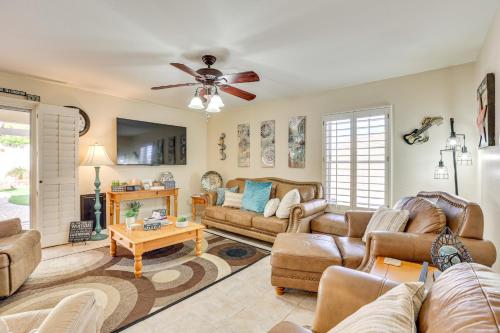 a living room with leather furniture and a ceiling fan at Pool, Patio and Hot Tub Surprise Home Near Golfing! in Surprise