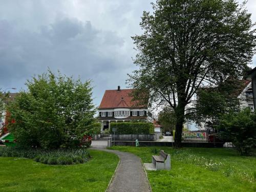a park with a bench in front of a house at VILLA Philipp Plein - Designervilla mit Pool & SPA in Amriswil