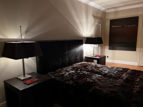 a bedroom with a black bed and two lamps at VILLA Philipp Plein - Designervilla mit Pool & SPA in Amriswil