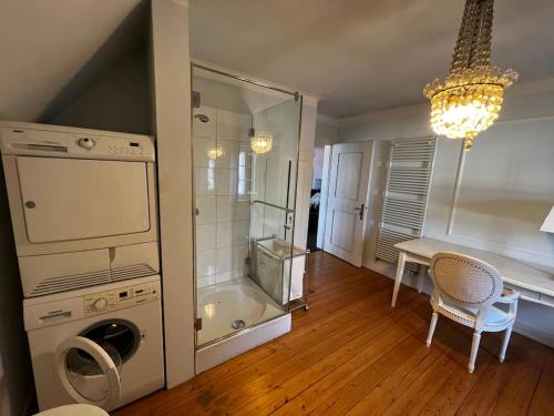 a bathroom with a washing machine and a table with chairs at VILLA Philipp Plein - Designervilla mit Pool & SPA in Amriswil