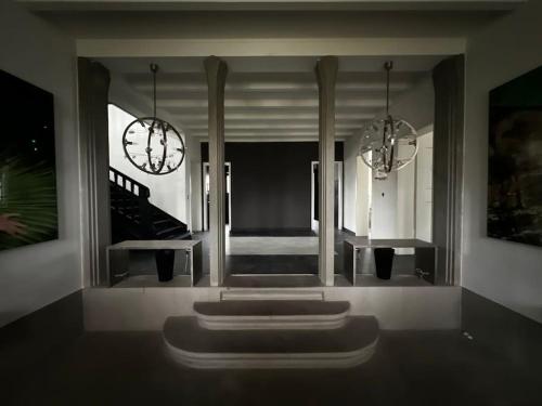 a living room with two chandeliers and a staircase at VILLA Philipp Plein - Designervilla mit Pool & SPA in Amriswil