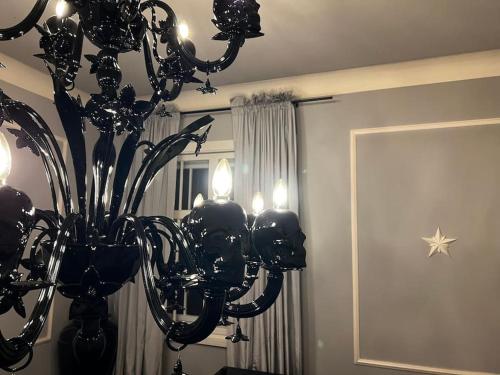 a black chandelier in a room with a mirror at VILLA Philipp Plein - Designervilla mit Pool & SPA in Amriswil