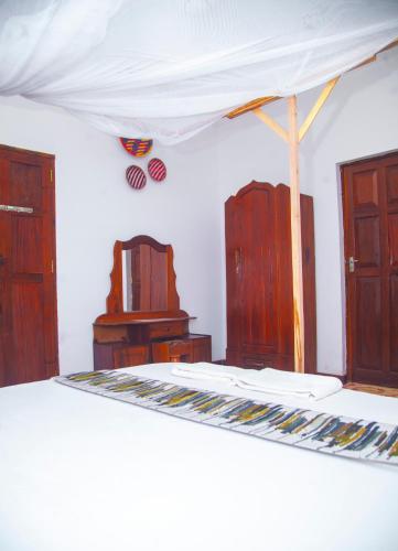 a room with a bed and some wooden furniture at SULKHAN SERVICED APARTMENT in Chukwani