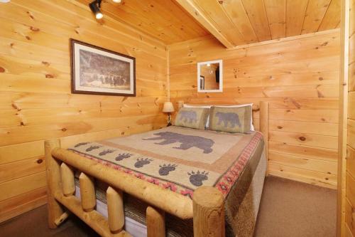 a bedroom with a bed in a log cabin at Thunder Bear Hideaway Roar Into Relaxation in Pigeon Forge